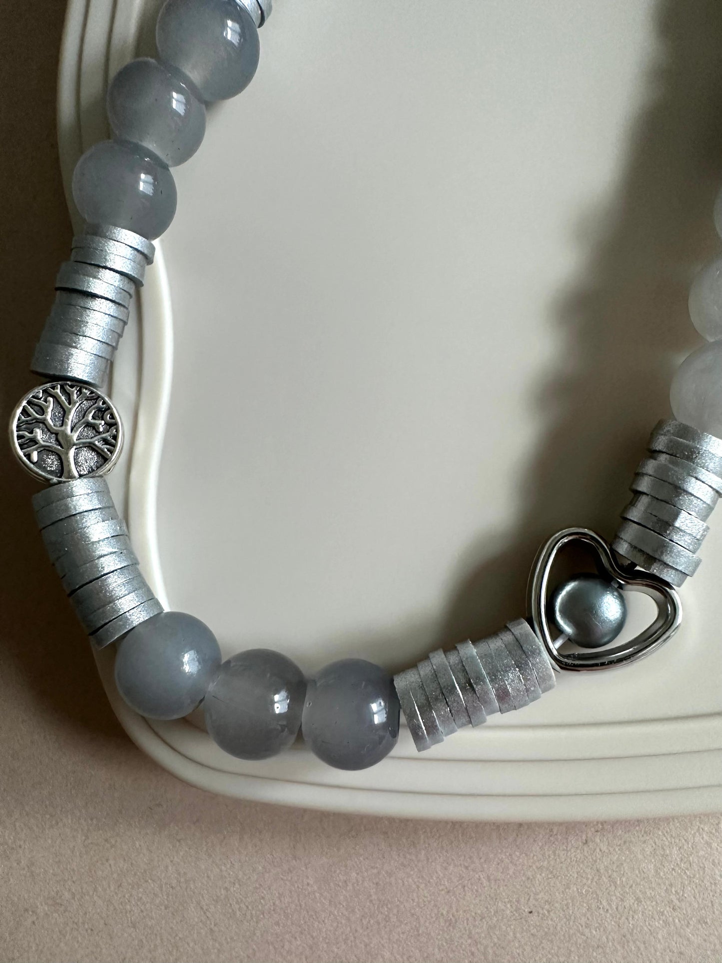 Grey handmade phone charm with glass beads attached to a phone case