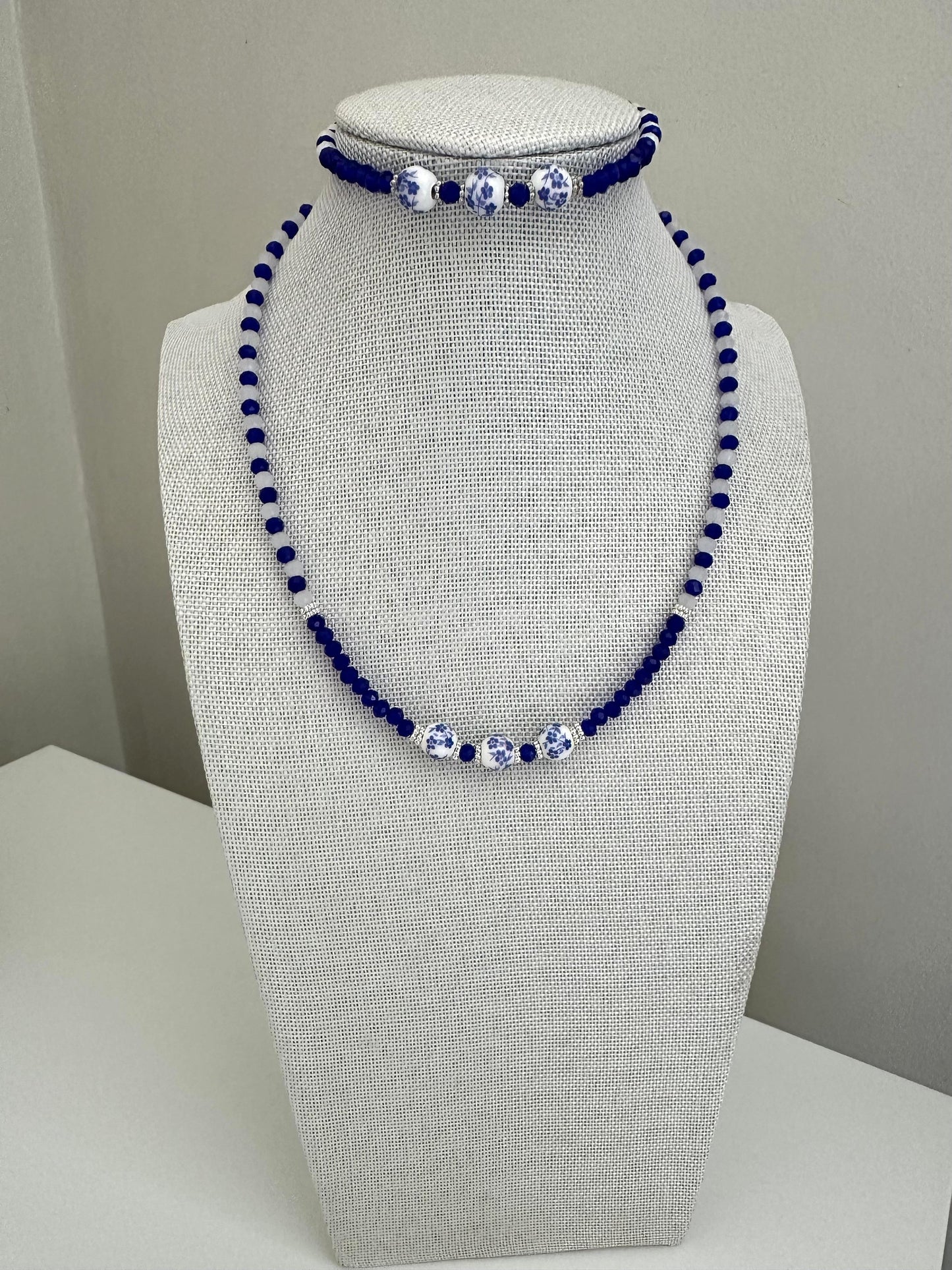 Handmade BLUVERDANT BLOSSOM bracelet with indigo and white glass beads, silver spacers, ceramic beads, and adjustable stainless steel chain