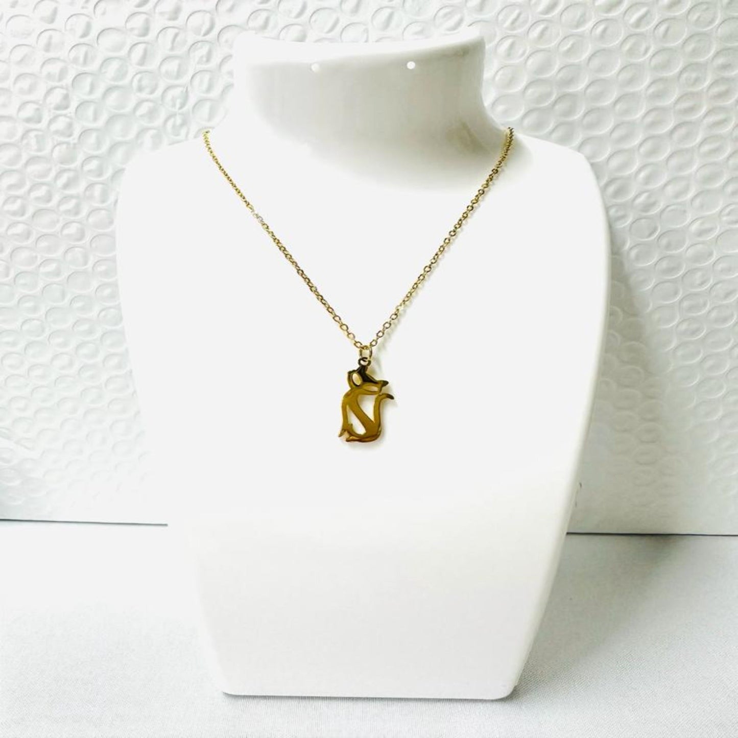 Gold stainless steel necklace with cat silhouette pendant on white background