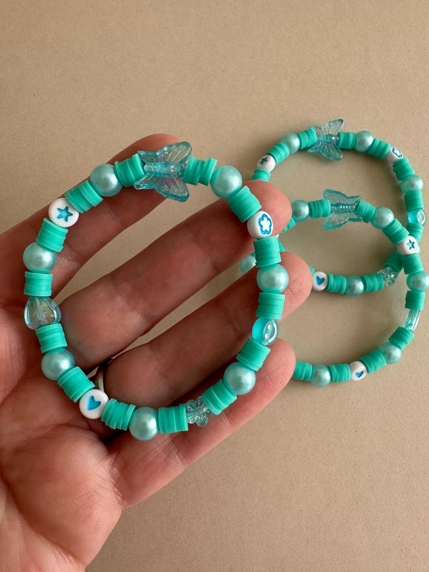 AQUA BREEZE stretch bracelet with blue polymer clay beads, iridescent faux pearls, and flower-shaped acrylic beads on elastic band
