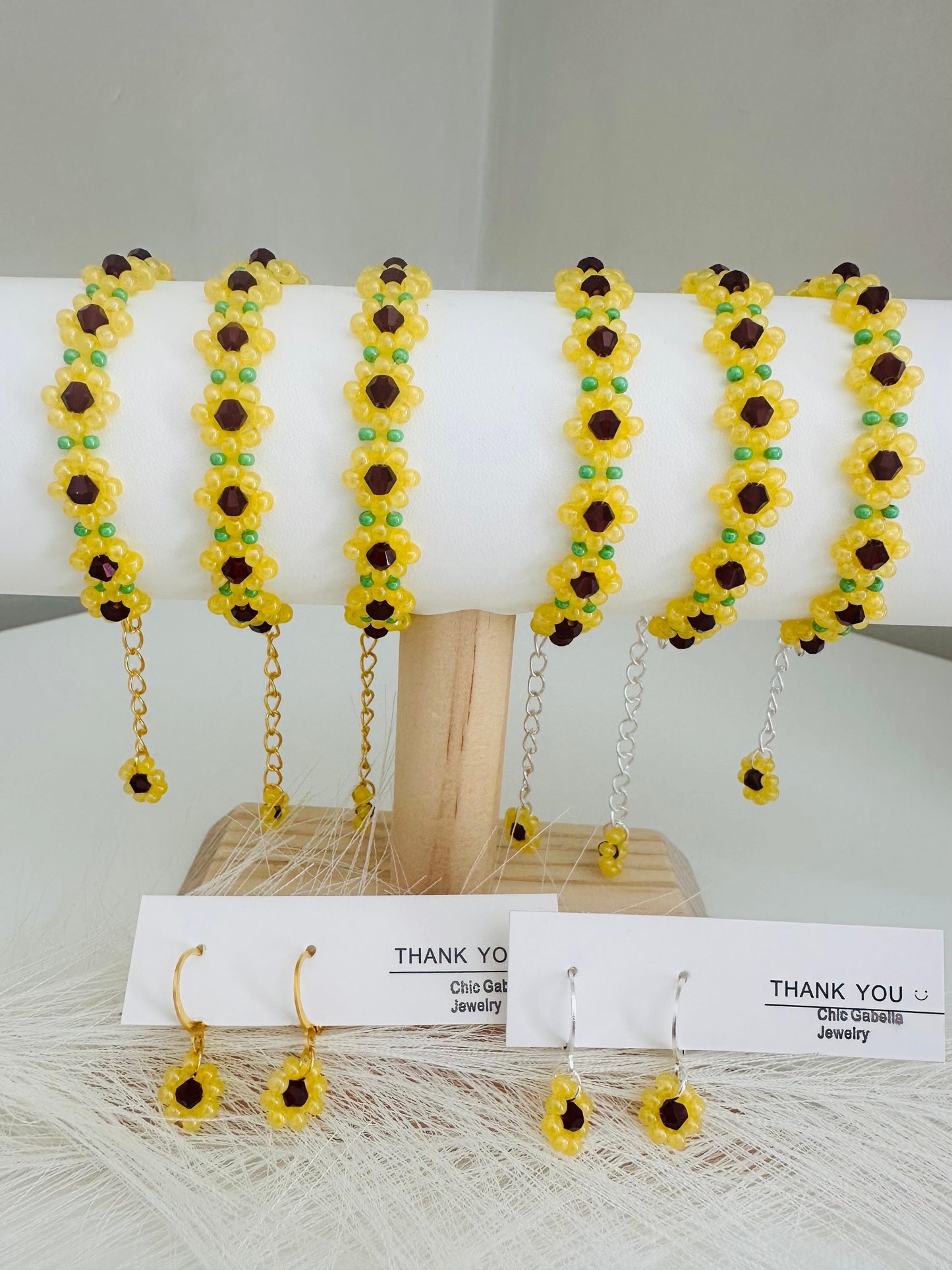 Handmade sunflower bloom earrings with gold and silver leverback hoops featuring yellow, brown, and green beads