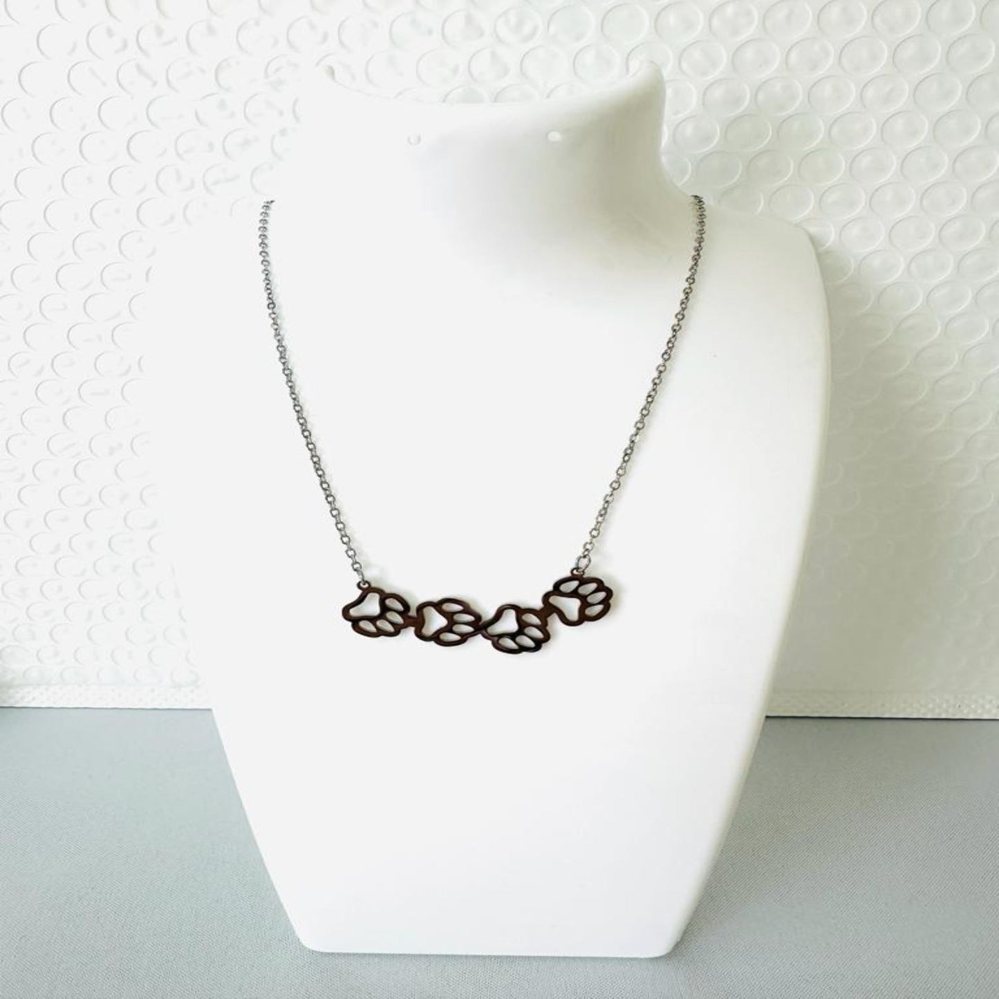 Elegant stainless steel necklace with four paw print pendant in gold and silver