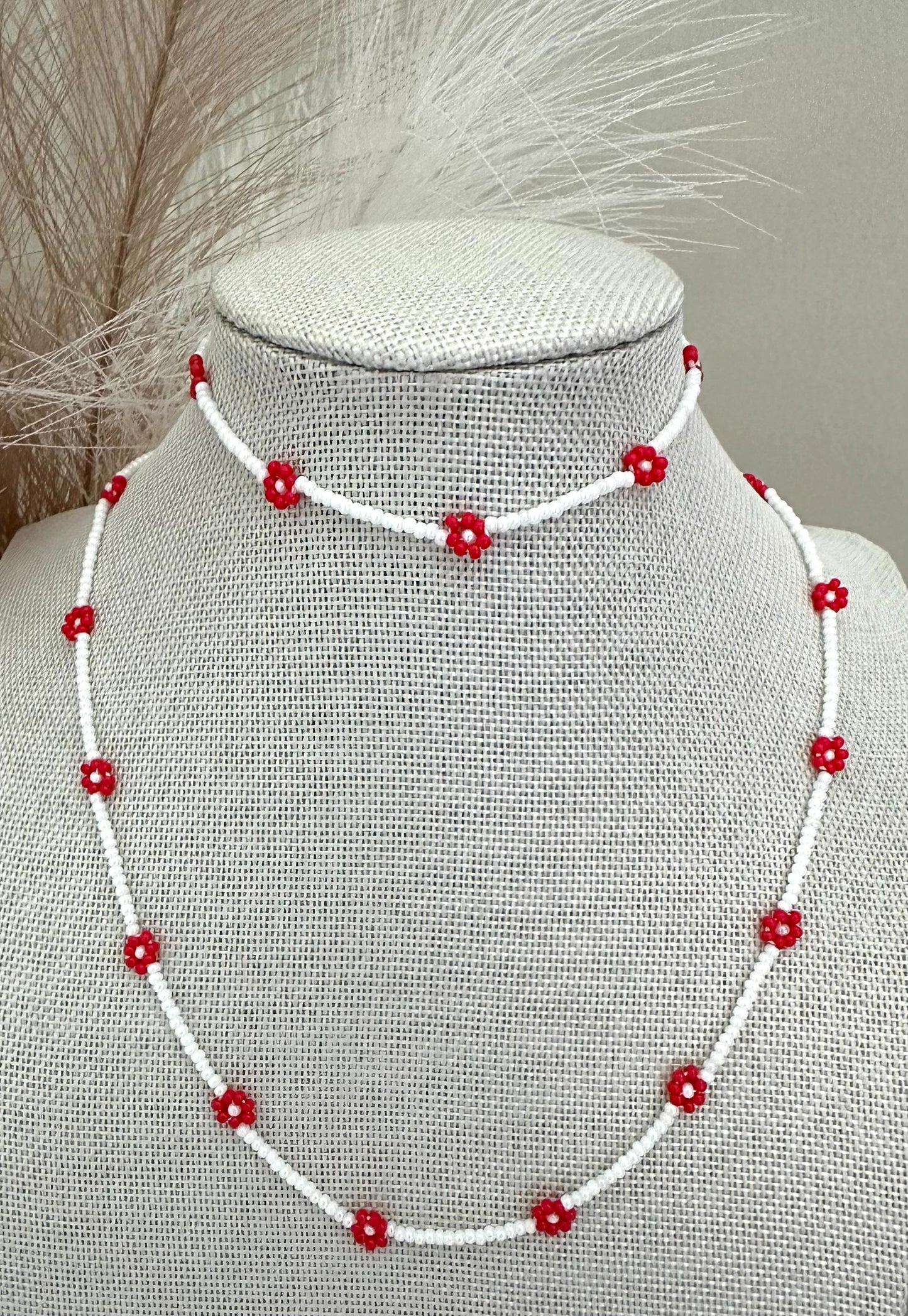 Red Bloom Delight handmade necklace with white glass beads and red flower accents on stainless steel chain