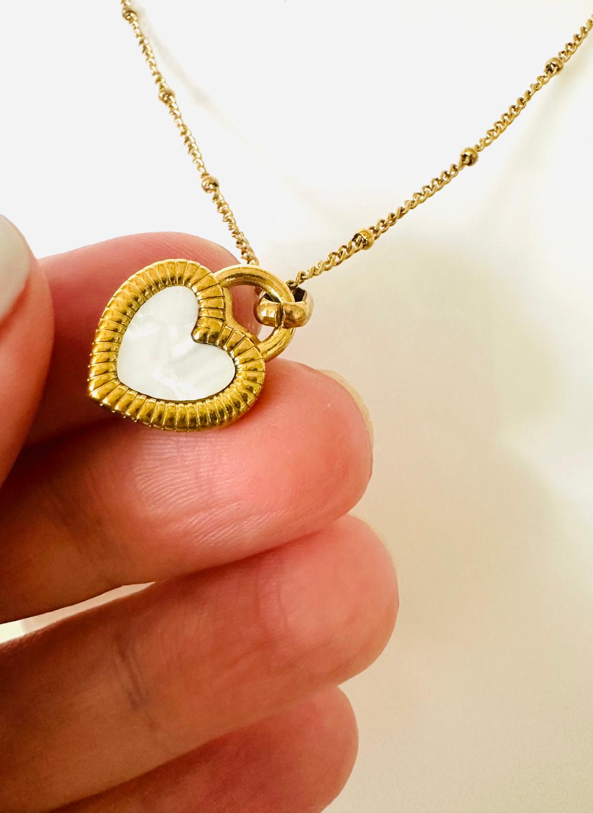 Gold stainless steel reversible heart necklace with black and white sides on a chain