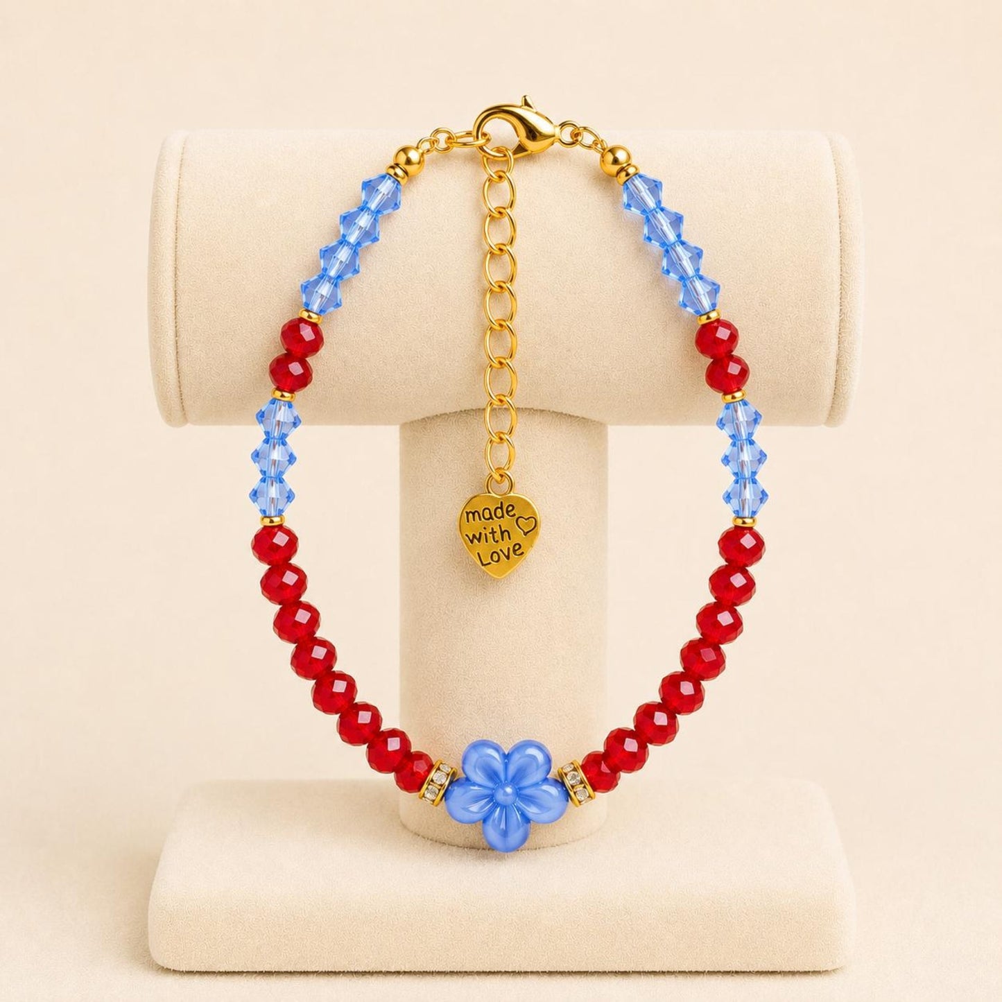 ADDISON handmade bracelet with blue and red crystal beads, gold accents, and flower-shaped ceramic bead on gold-plated chain