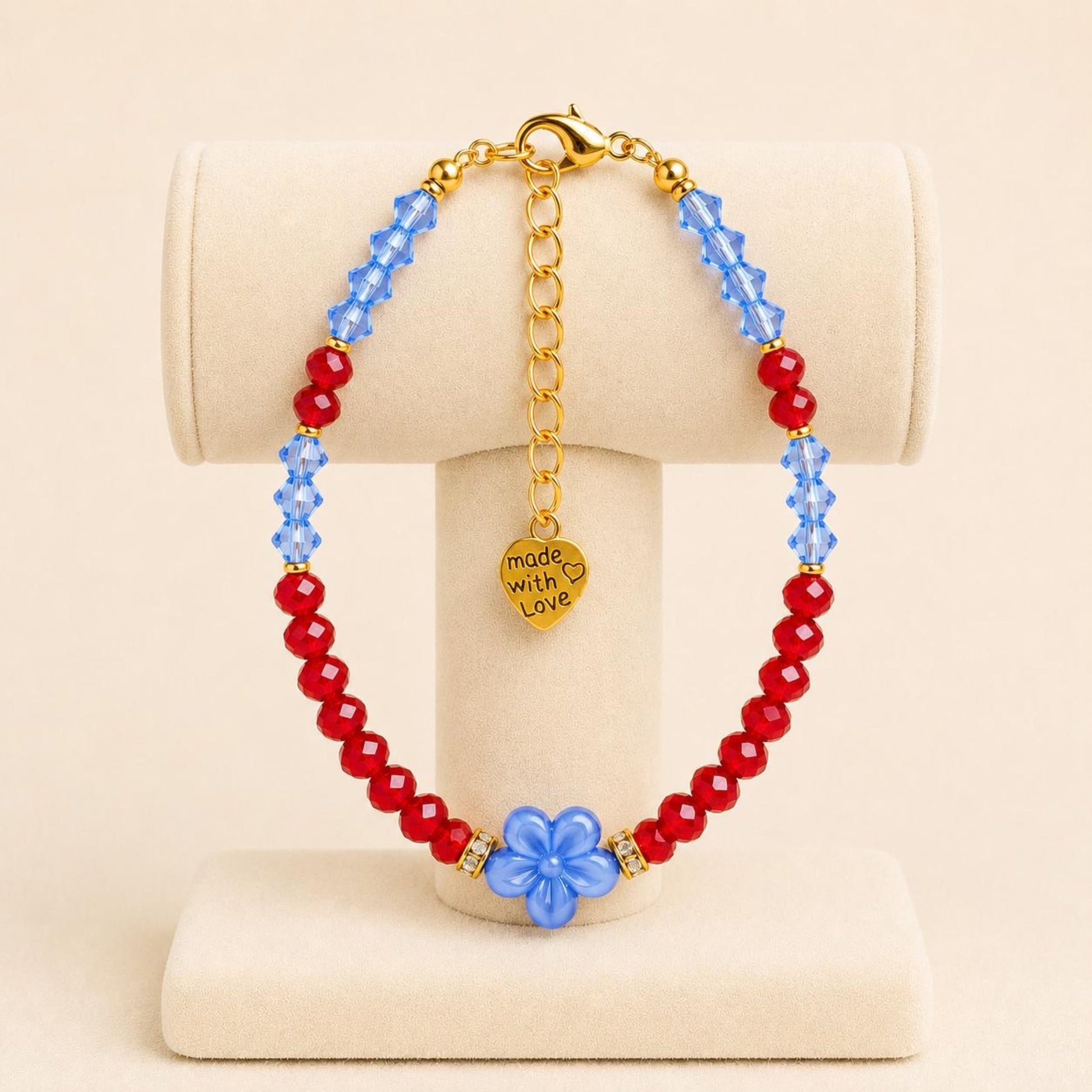 ADDISON handmade bracelet with blue and red crystal beads, gold accents, and flower-shaped ceramic bead on gold-plated chain