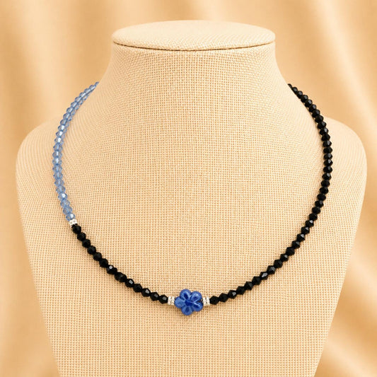 Handmade AUBREE necklace with blue and black crystal beads, silver rhinestone spacers, and blue flower ceramic bead on stainless steel chain