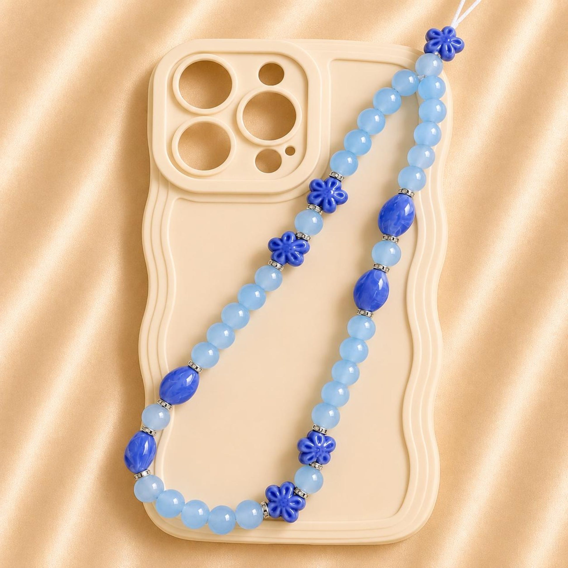 Handmade BLUE DREAM phone charm with blue glass beads attached to a phone case