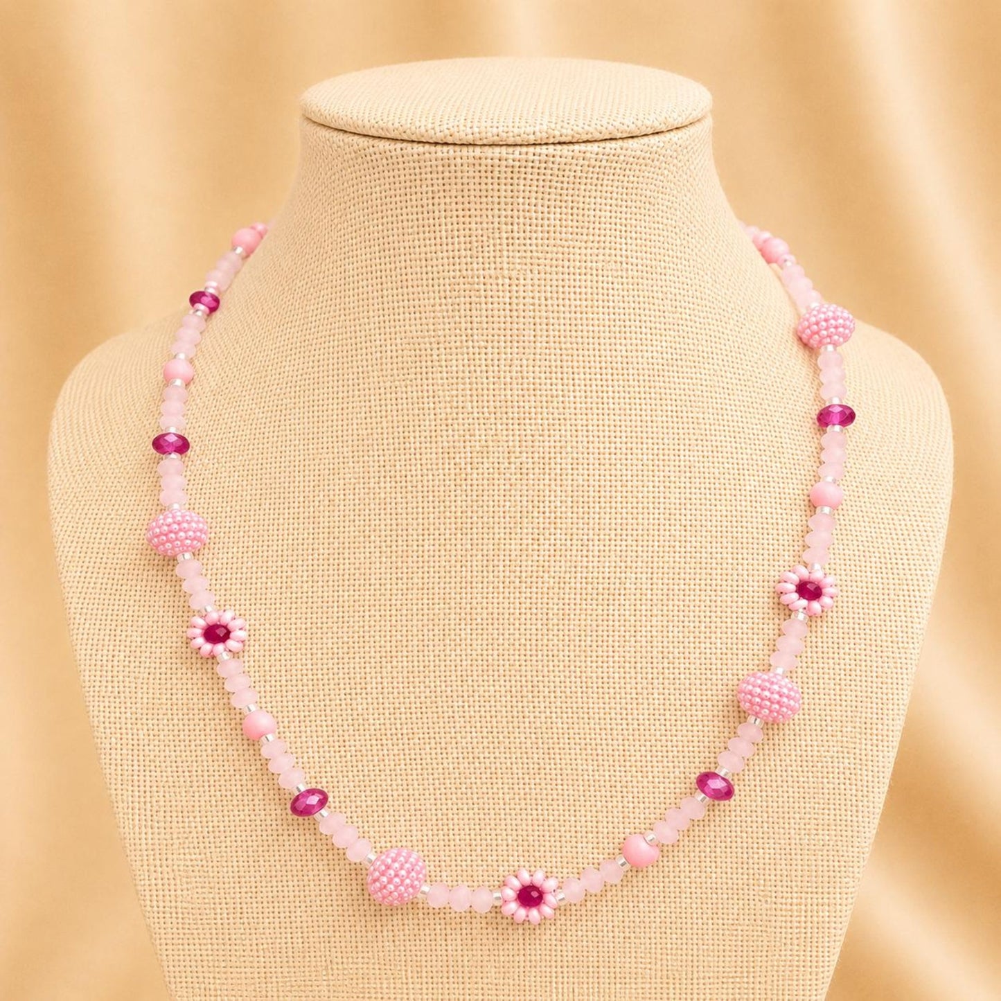Handmade blush tone necklace with pink and fuchsia glass beads, faux pearls, and floral details on stainless steel chain