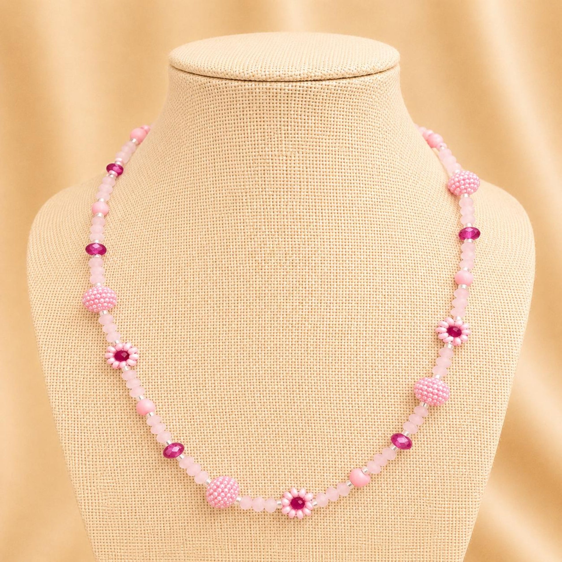 Handmade blush tone necklace with pink and fuchsia glass beads, faux pearls, and floral details on stainless steel chain
