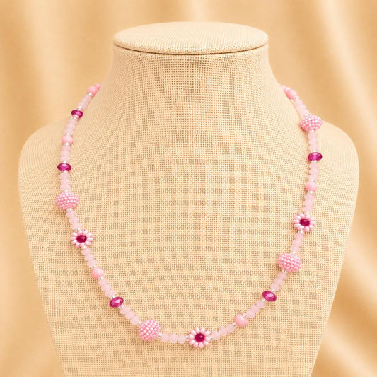 Handmade blush tone necklace with pink and fuchsia glass beads, faux pearls, and floral details on stainless steel chain