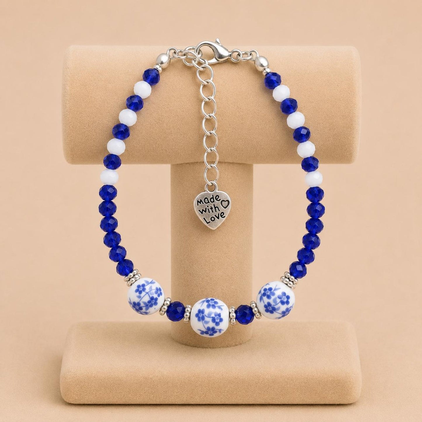 Handmade BLUVERDANT BLOSSOM bracelet with indigo, white glass, silver spacer, and ceramic beads on nylon string with stainless steel clasp