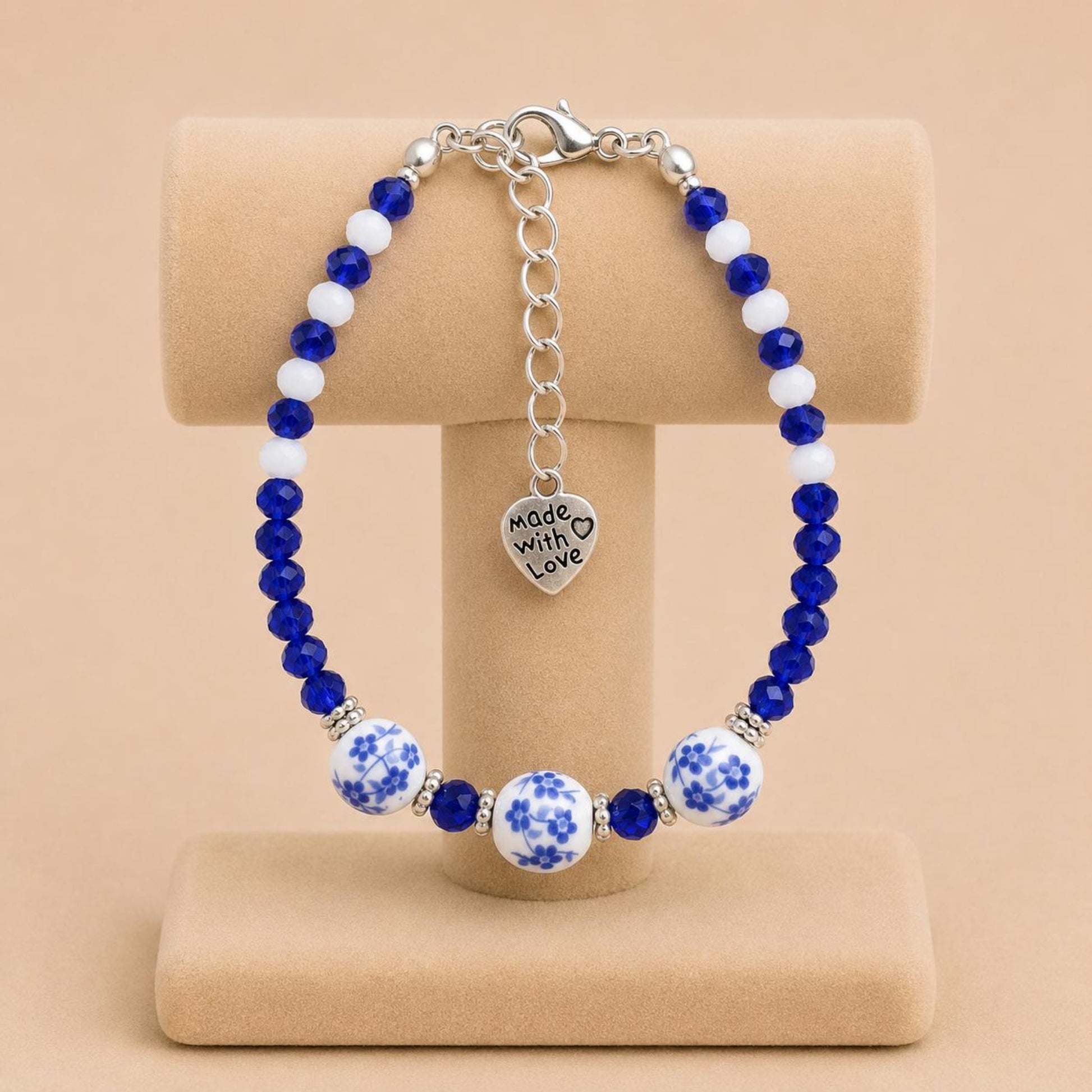 Handmade BLUVERDANT BLOSSOM bracelet with indigo, white glass, silver spacer, and ceramic beads on nylon string with stainless steel clasp