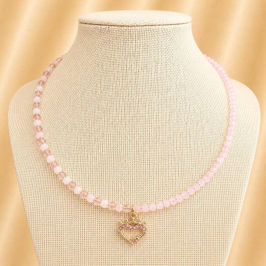 Handmade necklace featuring pink glass beads and a gold heart pendant with pink rhinestones