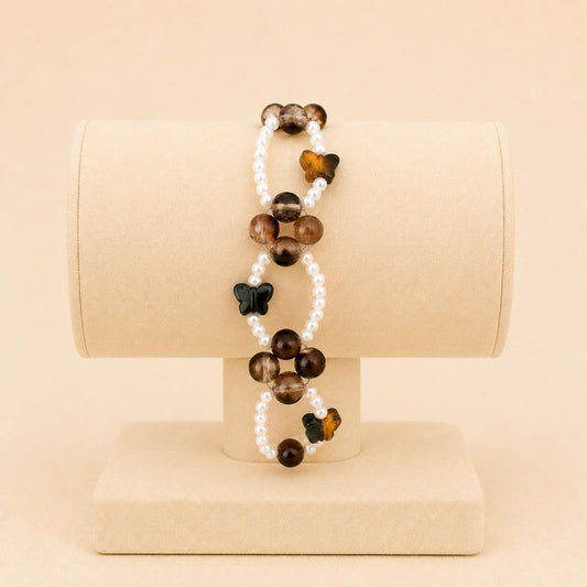 Butterfly Earth Harmony stretch bracelet with white faux pearls, brown glass beads, and crystal butterfly beads on elastic band