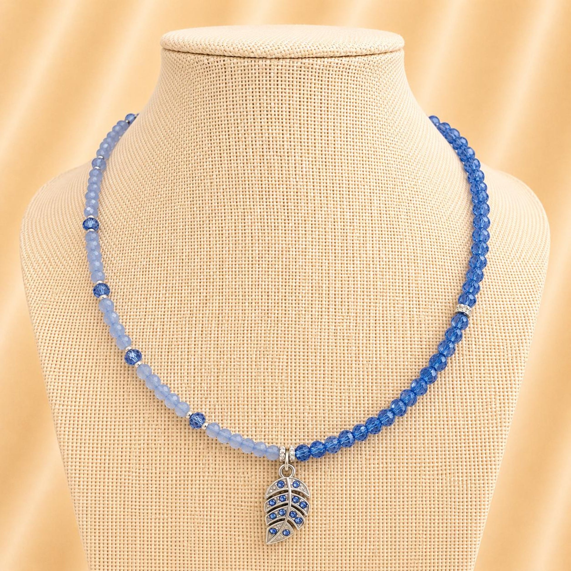 Handmade TESSA necklace with blue crystal beads, silver rhinestones, and leaf design on stainless steel chain