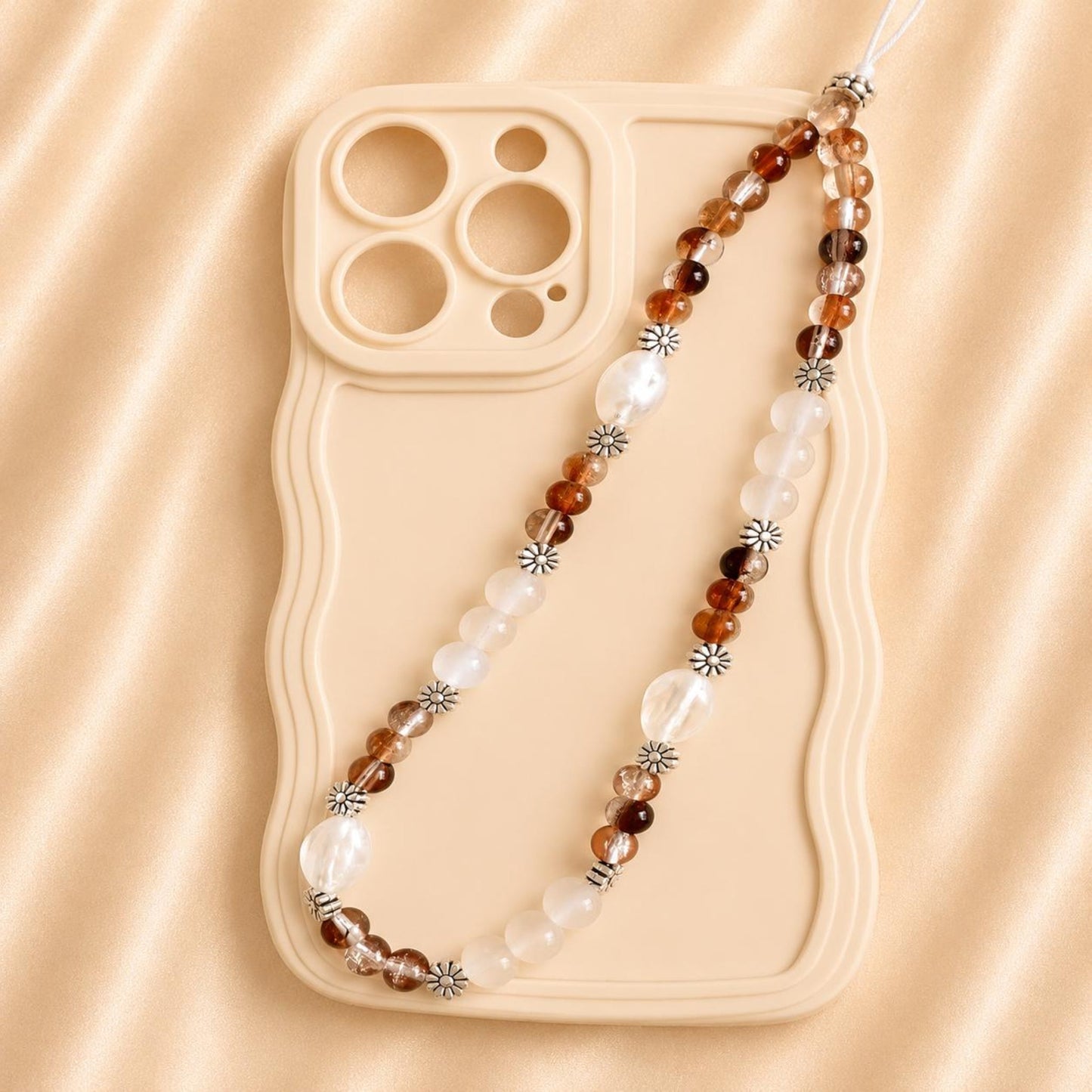 Handmade EARTHY DREAM phone charm with glass beads attached to white smartphone