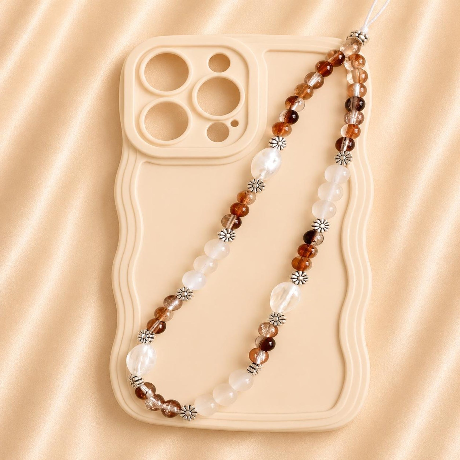 Handmade EARTHY DREAM phone charm with glass beads attached to white smartphone