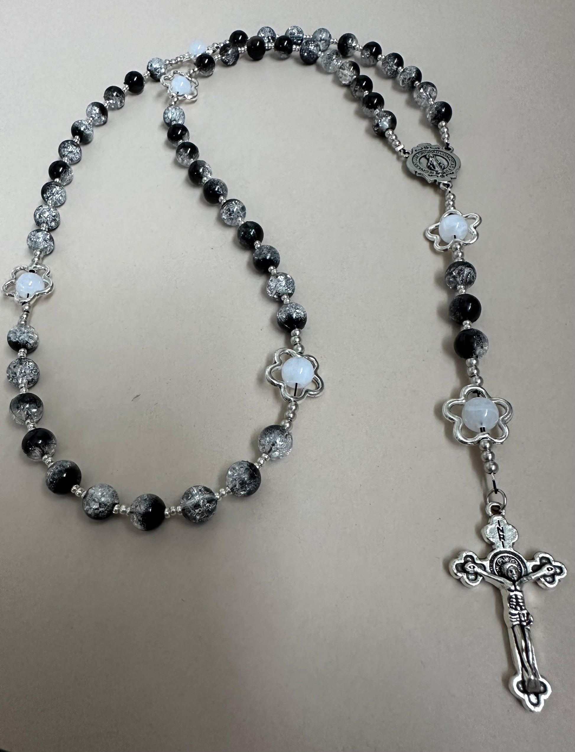 Midnight Bloom Handmade Rosary with black glass beads and silver-tone flower accents on a wooden background