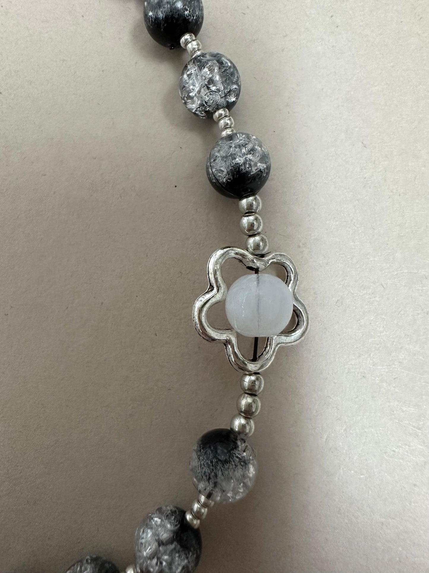 Midnight Bloom Handmade Rosary with black glass beads and silver-tone flower accents on a wooden background