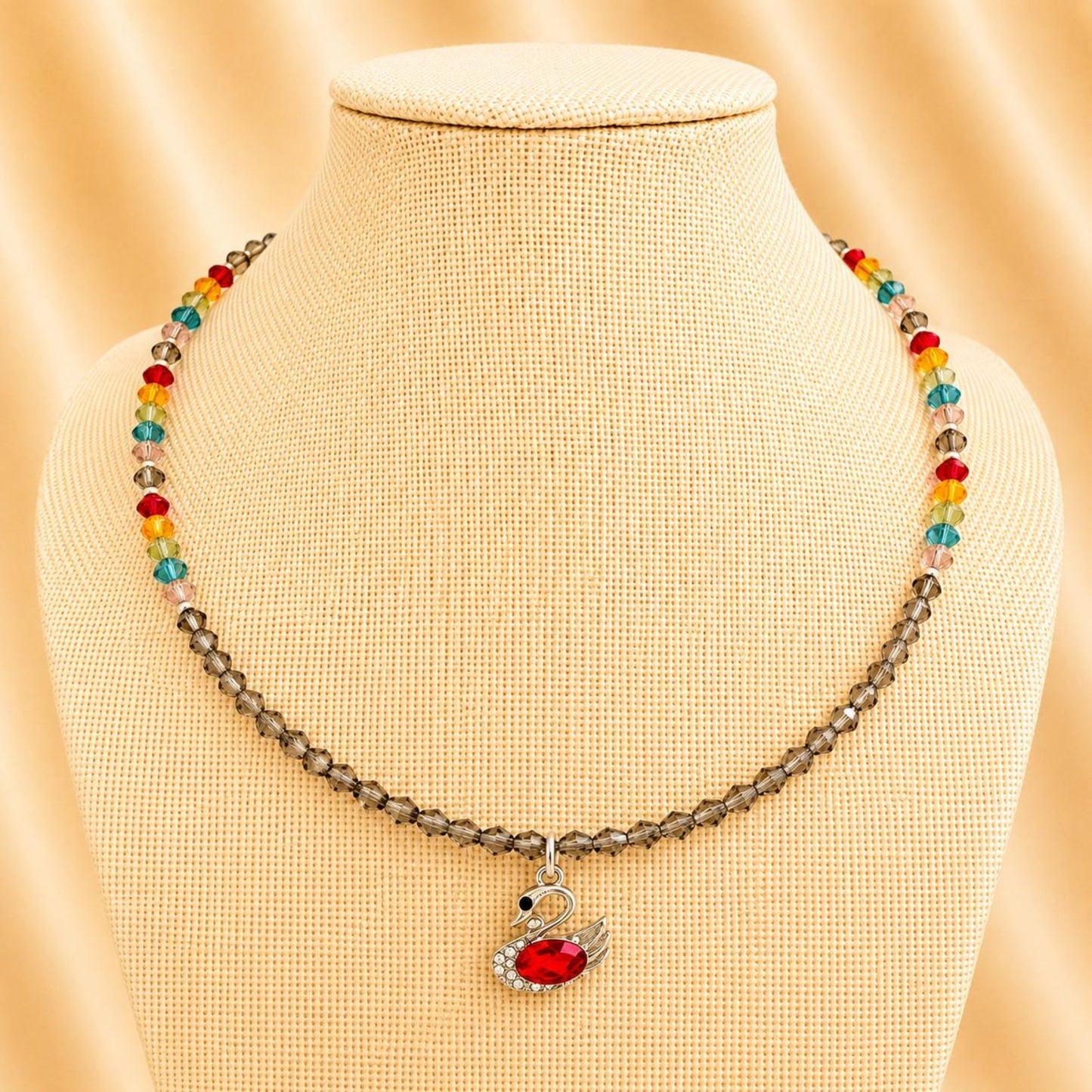 Handmade necklace with colorful crystal beads and silver swan pendant featuring a red rhinestone