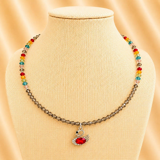Handmade necklace with colorful crystal beads and silver swan pendant featuring a red rhinestone