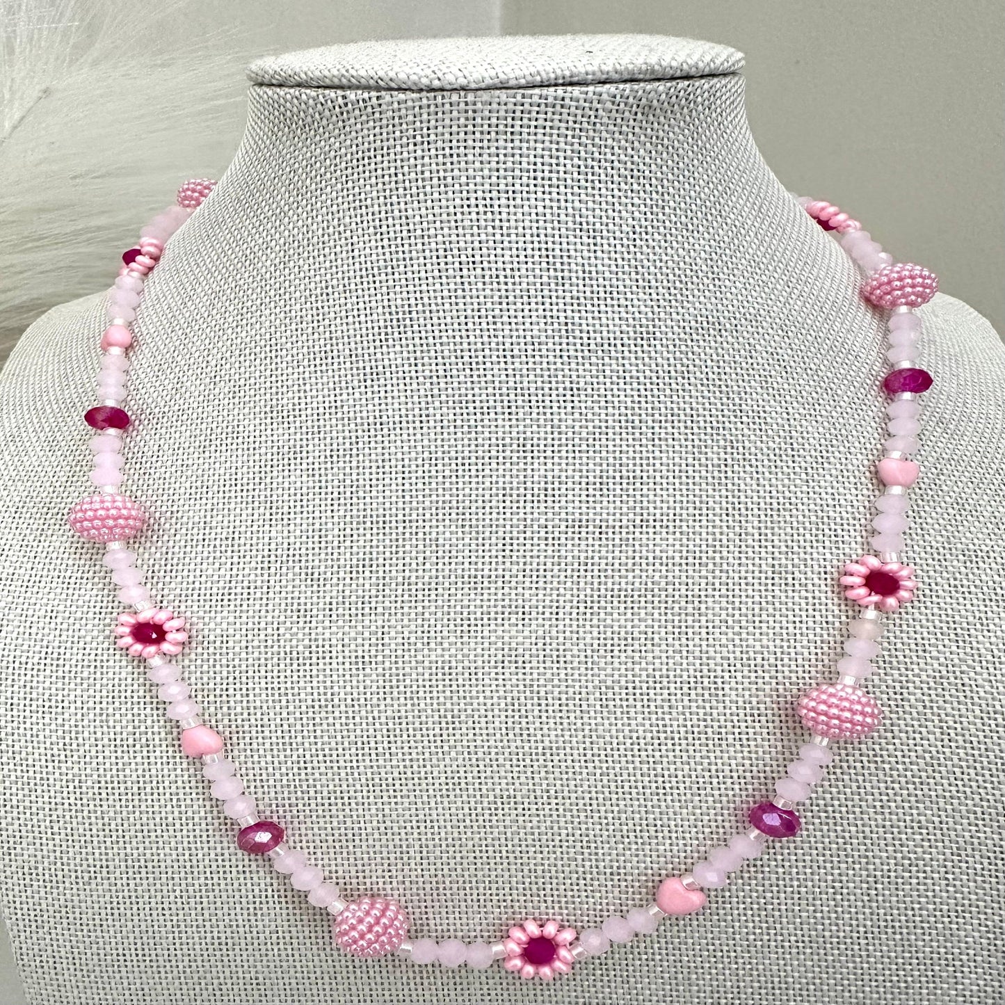 Blush tone handmade necklace with pink and fuchsia glass beads, faux pearls, and floral details on stainless steel chain