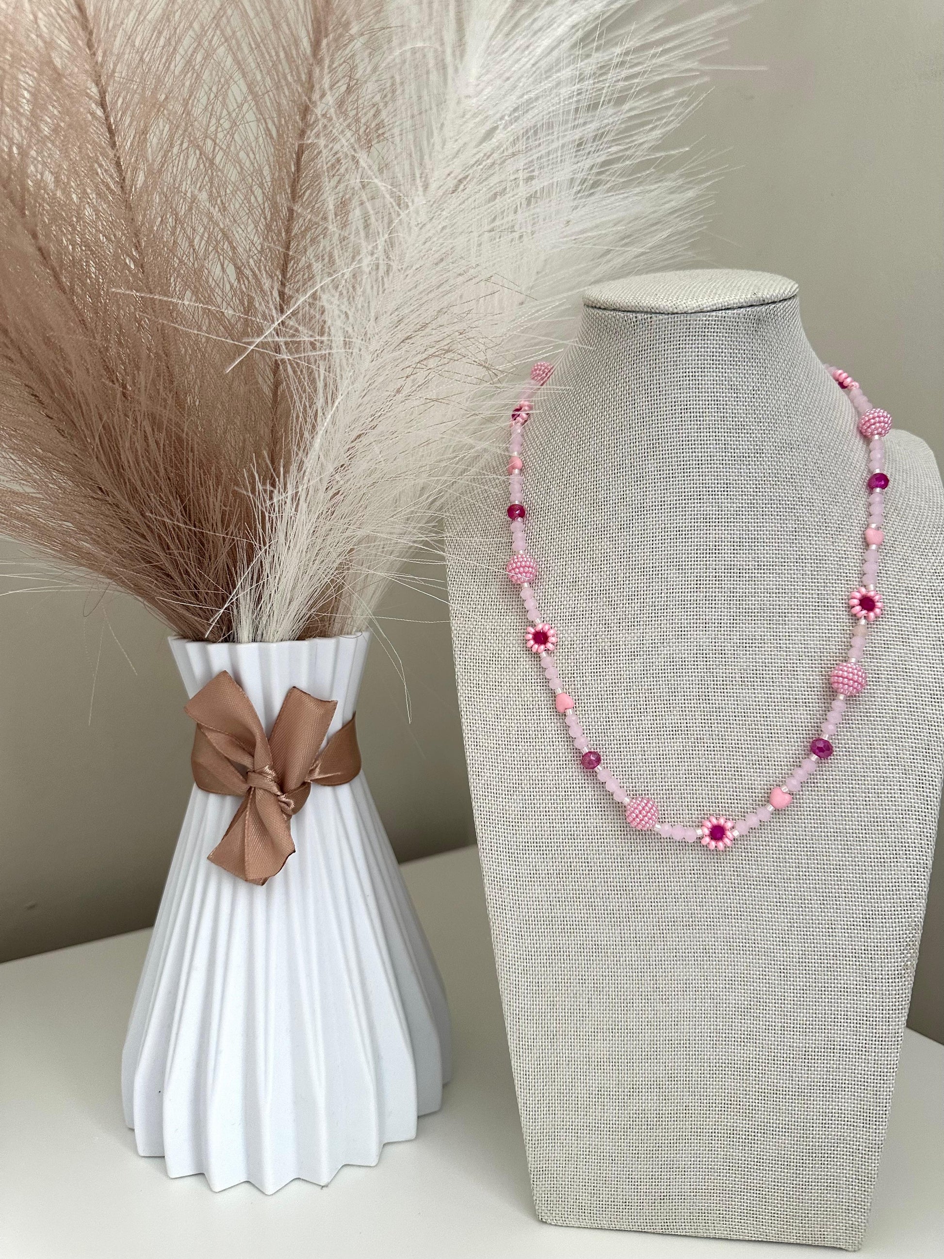 Blush tone handmade necklace with pink beads, faux pearls, and floral details on stainless steel chain