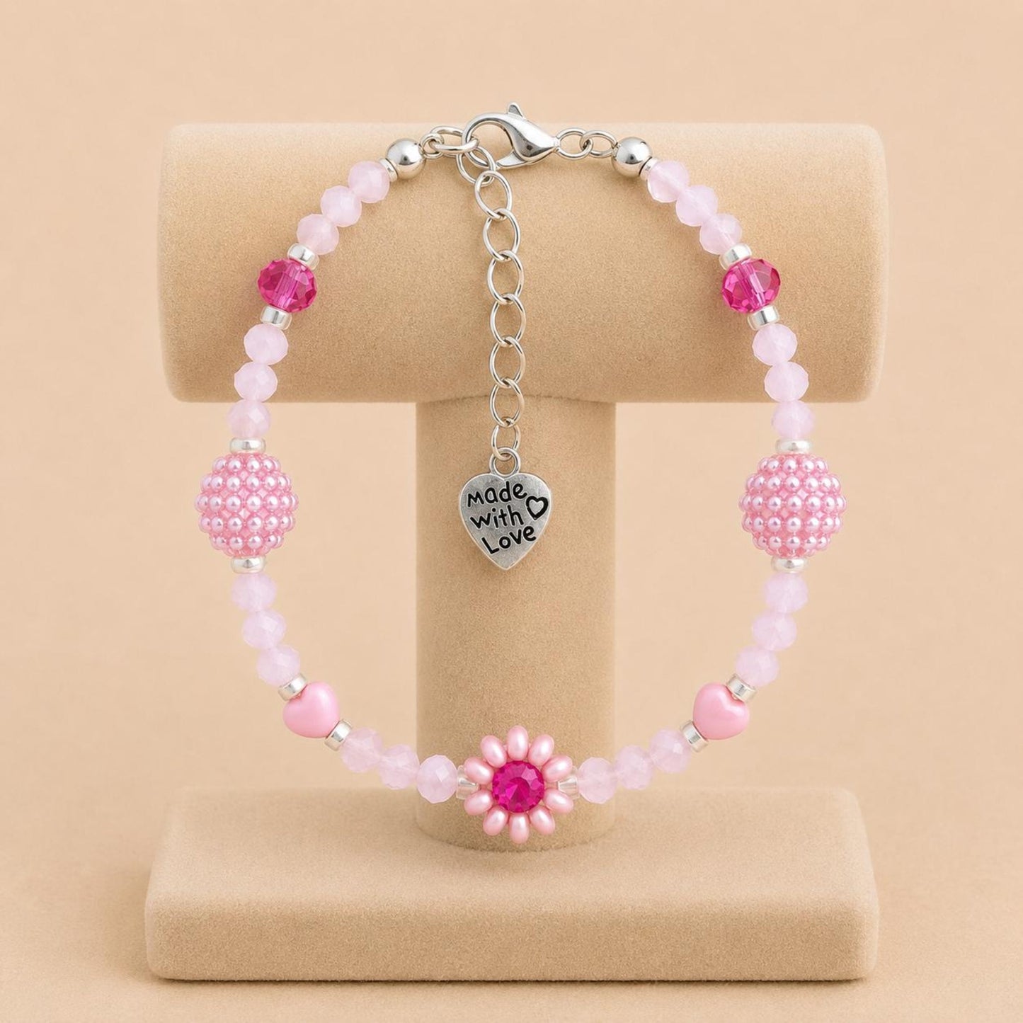 Handmade blush tone bracelet with pink and fuchsia glass beads, faux pearls, and floral details on stainless steel chain