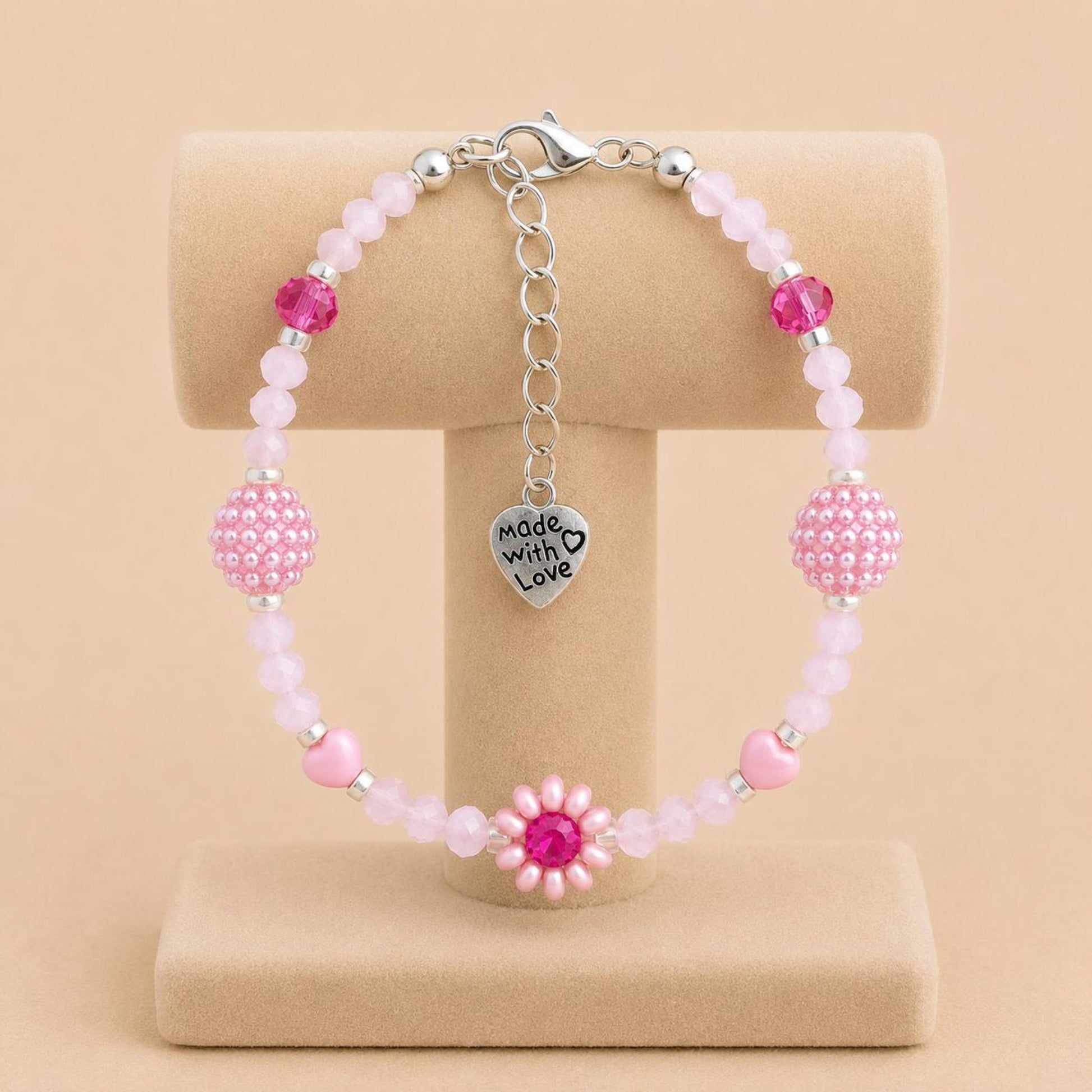 Handmade blush tone bracelet with pink and fuchsia glass beads, faux pearls, and floral details on stainless steel chain