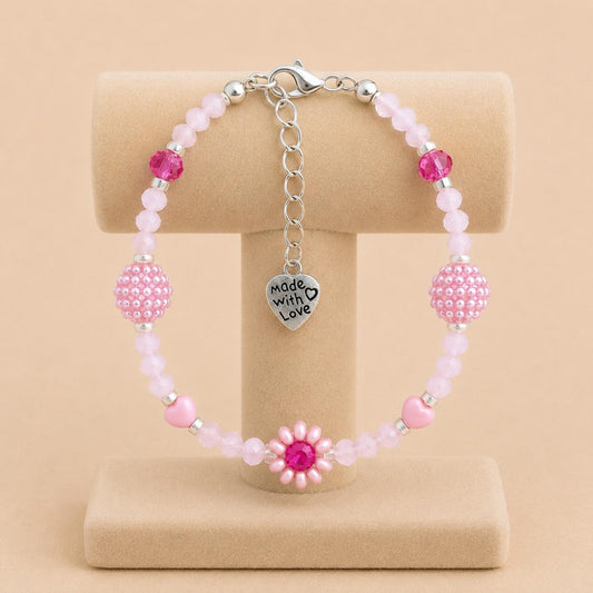 Handmade blush tone bracelet with pink and fuchsia glass beads, faux pearls, and floral details on stainless steel chain
