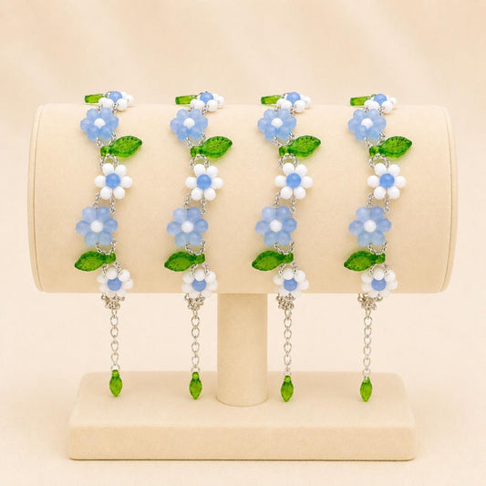 Handmade EVERYDAY FLORAL bracelet with white and blue glass beads, silver seed beads, and green leaf accents