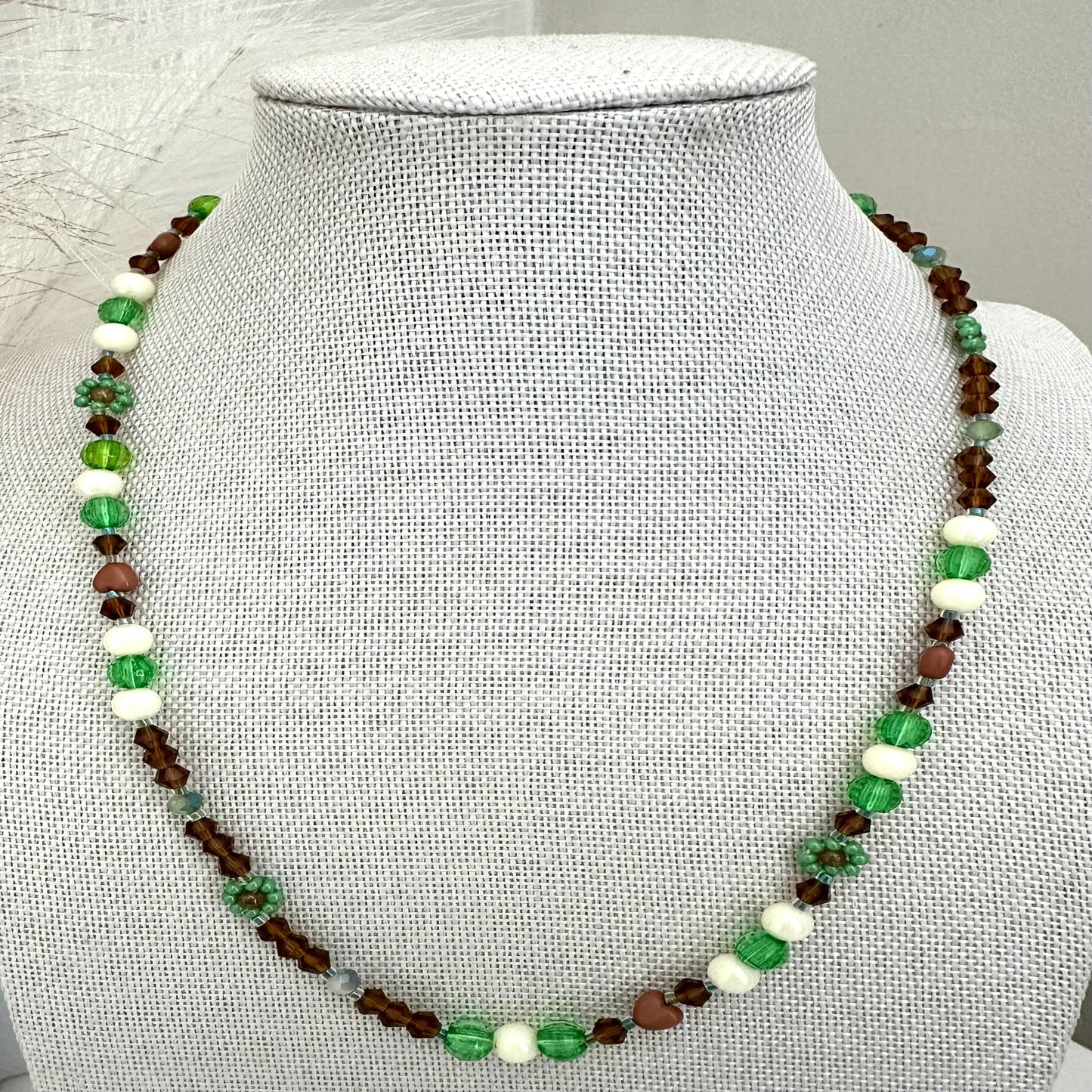 Handmade MORNING DEW necklace with brown and green glass beads and floral details on stainless steel chain