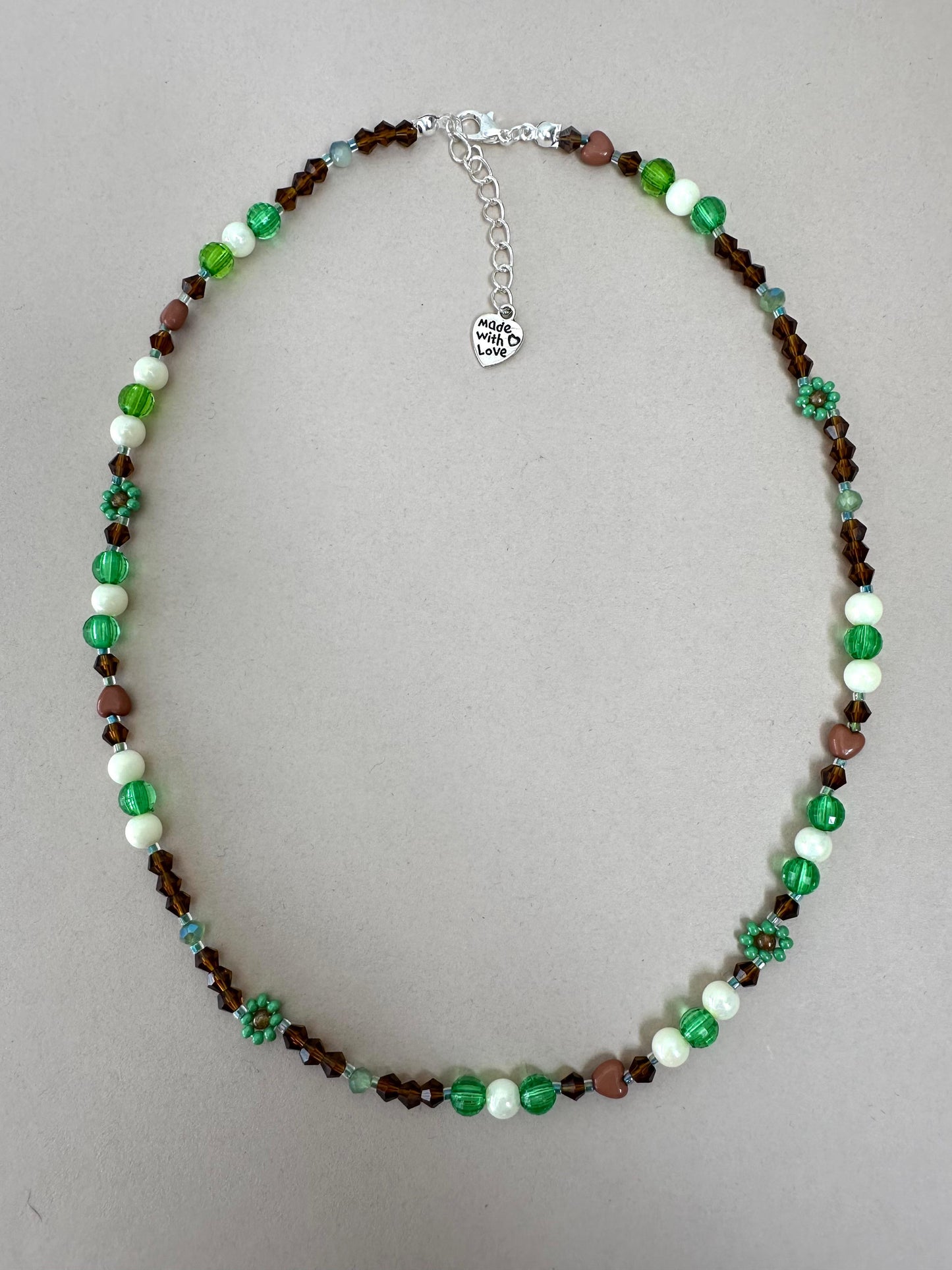 Handmade MORNING DEW necklace with brown and green glass beads and floral details on stainless steel chain