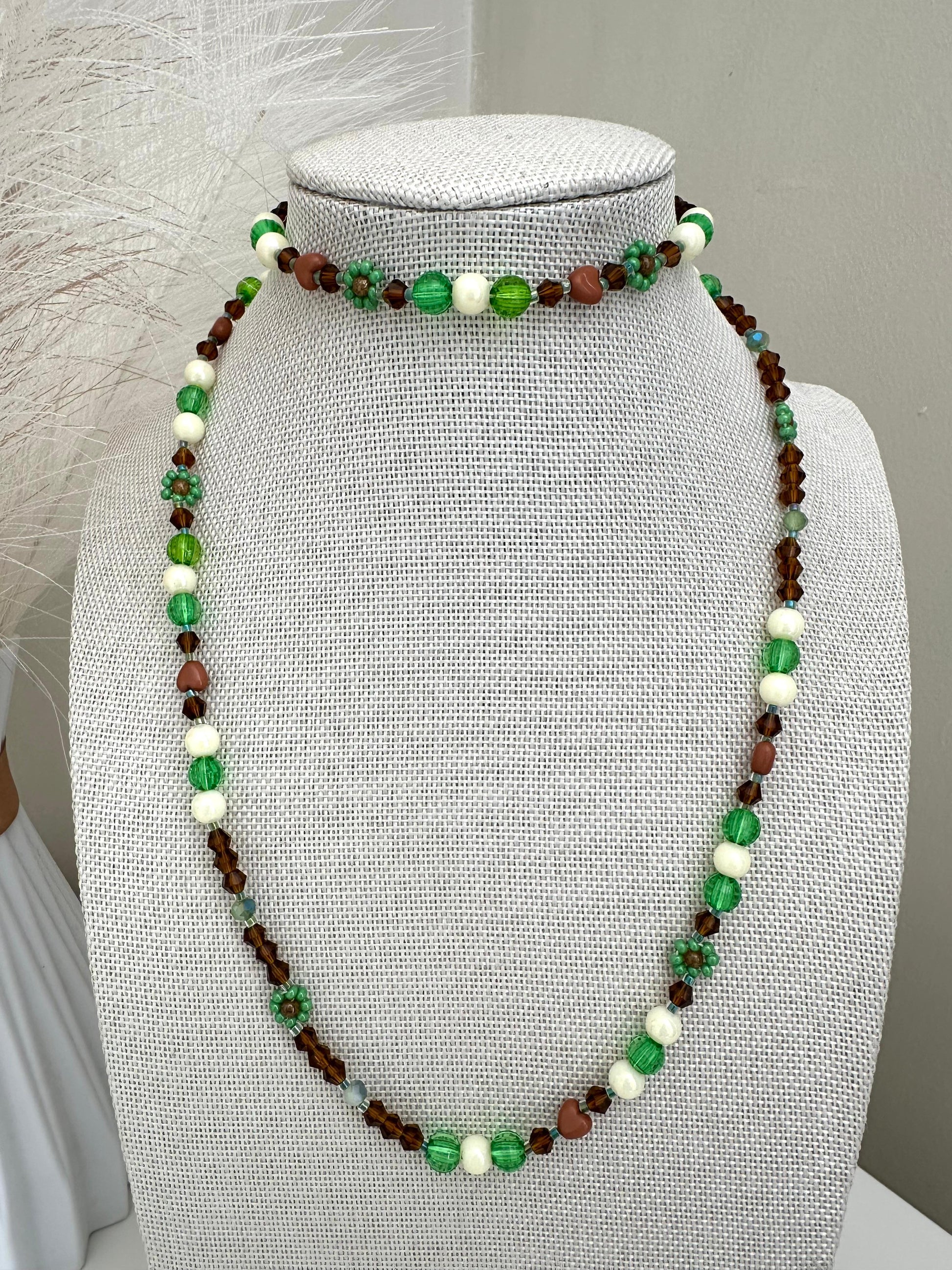 Handmade MORNING DEW necklace with brown and green glass beads and floral details on stainless steel chain