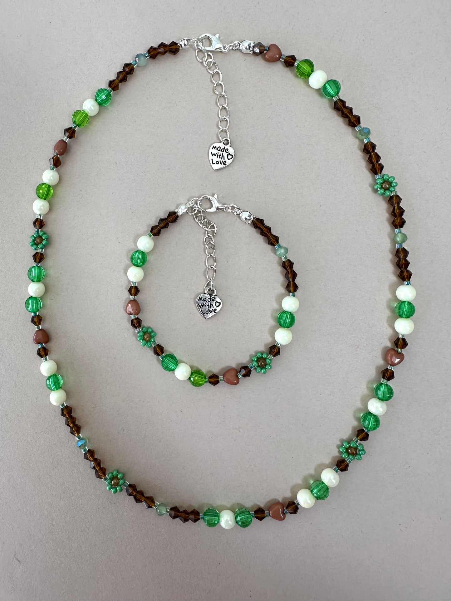 Handmade MORNING DEW necklace with brown and green glass beads and floral details on stainless steel chain
