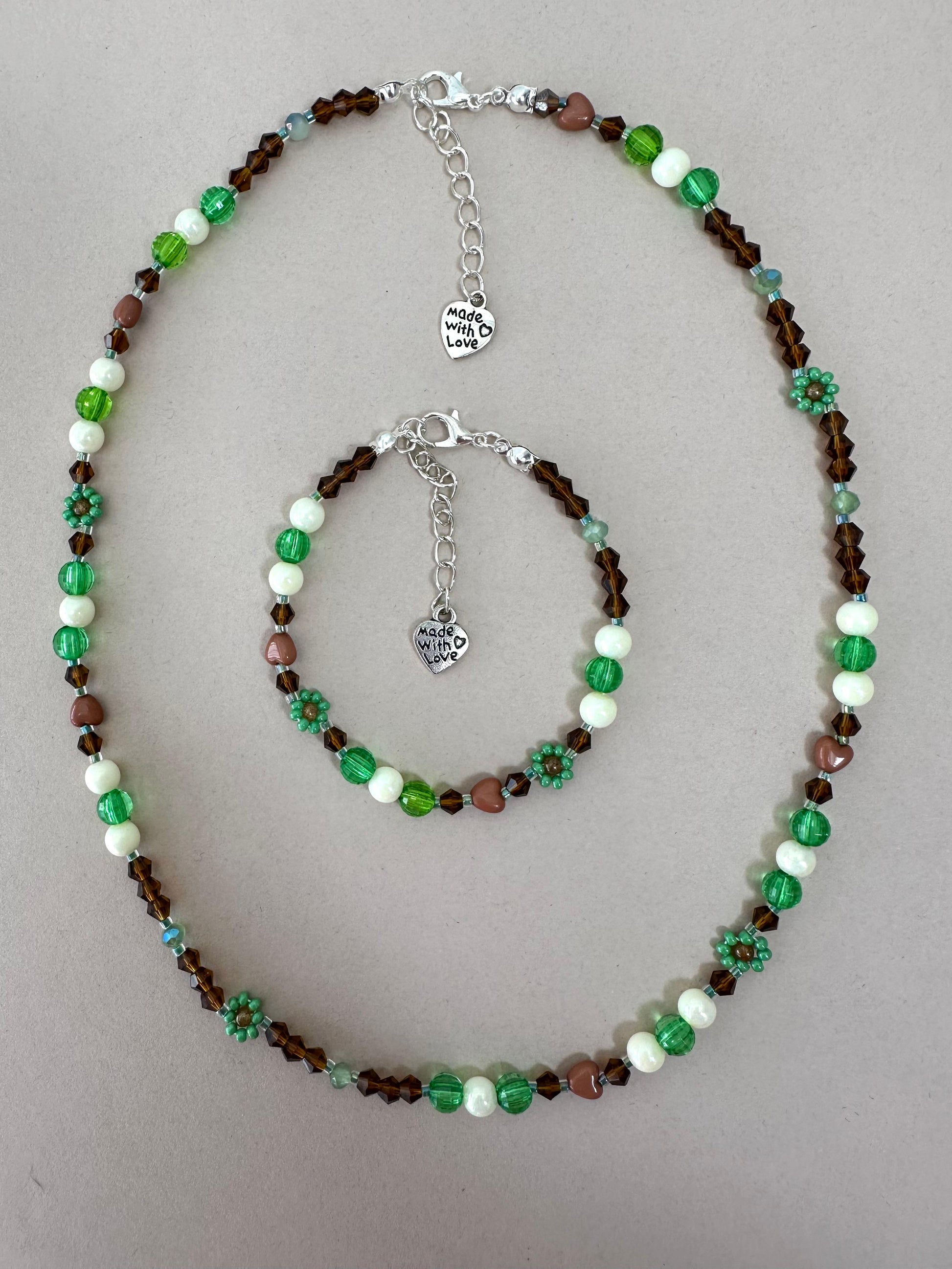 Handmade MORNING DEW necklace with brown and green glass beads and floral details on stainless steel chain