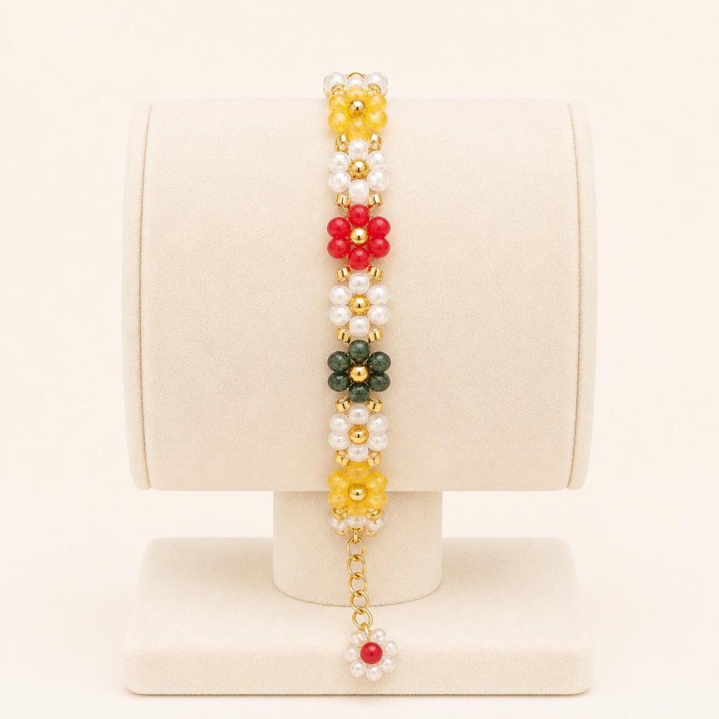 Colorful flower handmade bracelet with white, green, red, and yellow beads and gold accents on a nylon string