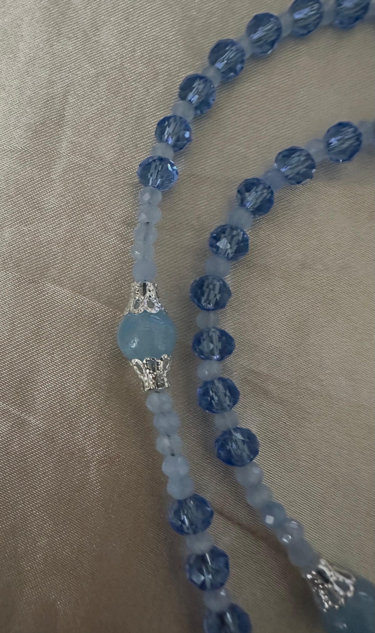 Blue Serenity Handmade Rosary with faceted dark blue and pale blue glass beads, silver-tone filigree caps and crucifix.