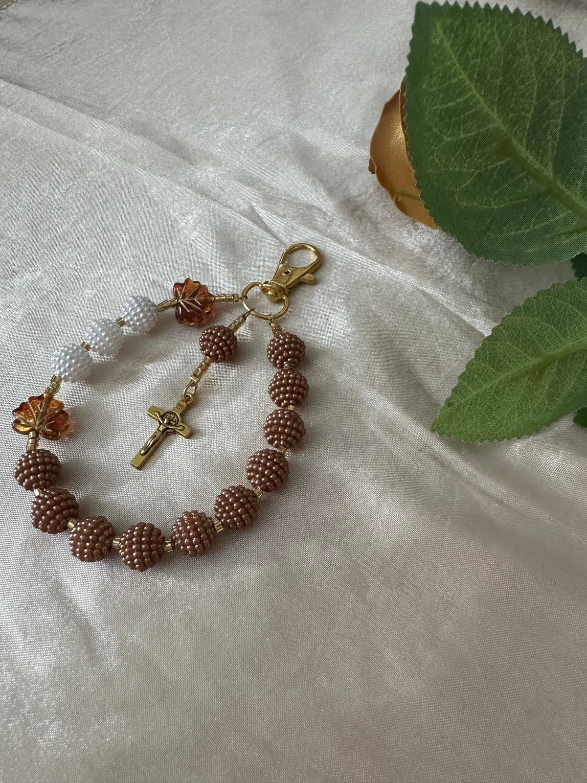Cocoa Grace Handmade Catholic Keychain with textured brown and white beads, amber leaf accents and a gold-tone crucifix