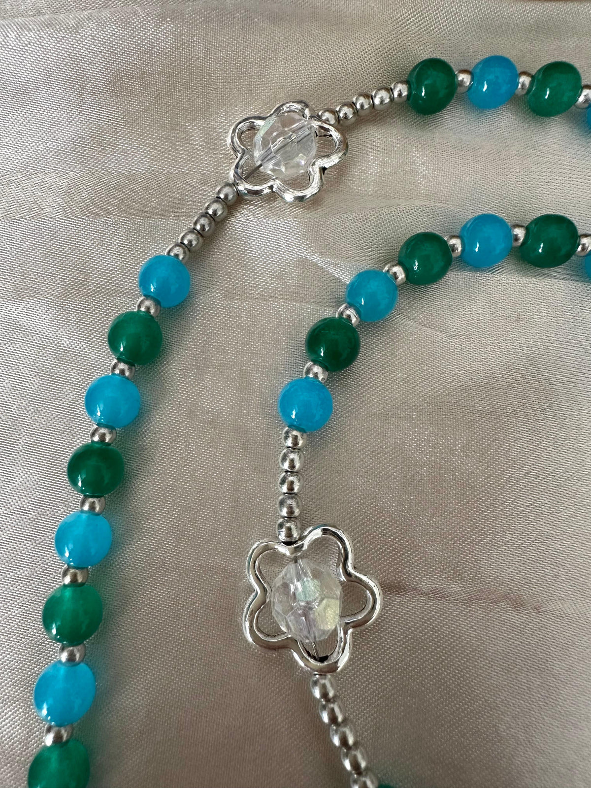 Ocean Bloom Handmade Rosary with green and turquoise glass beads, silver-tone flower-shaped accents, and centerpiece crucifix