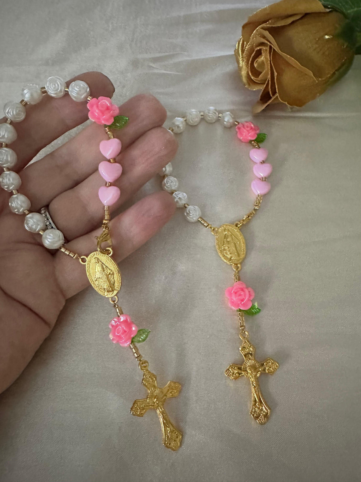 Pink Rose Mini Rosary with ivory rose-shaped beads, pink heart beads and flowers, green leaves, and gold-tone crucifix.