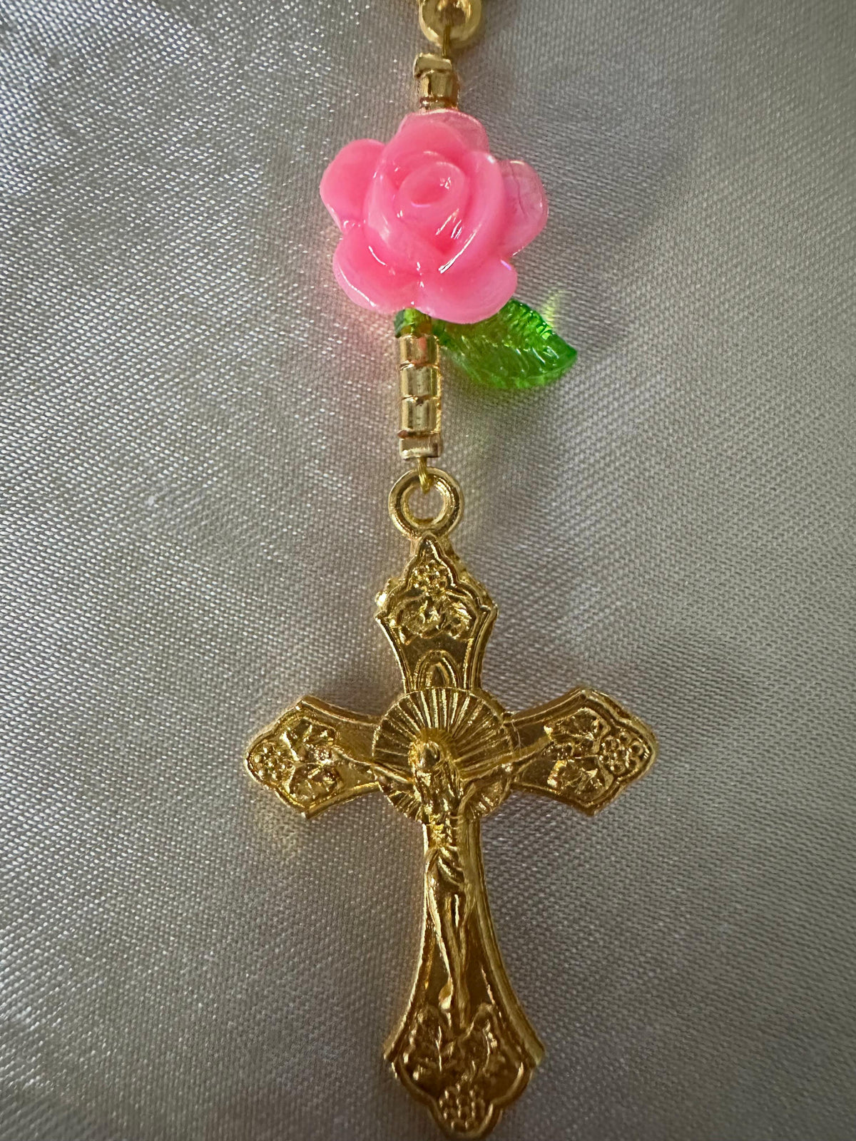 Pink Rose Mini Rosary with a glossy pink rose bead, green leaf, and ornate gold-tone crucifix and links.