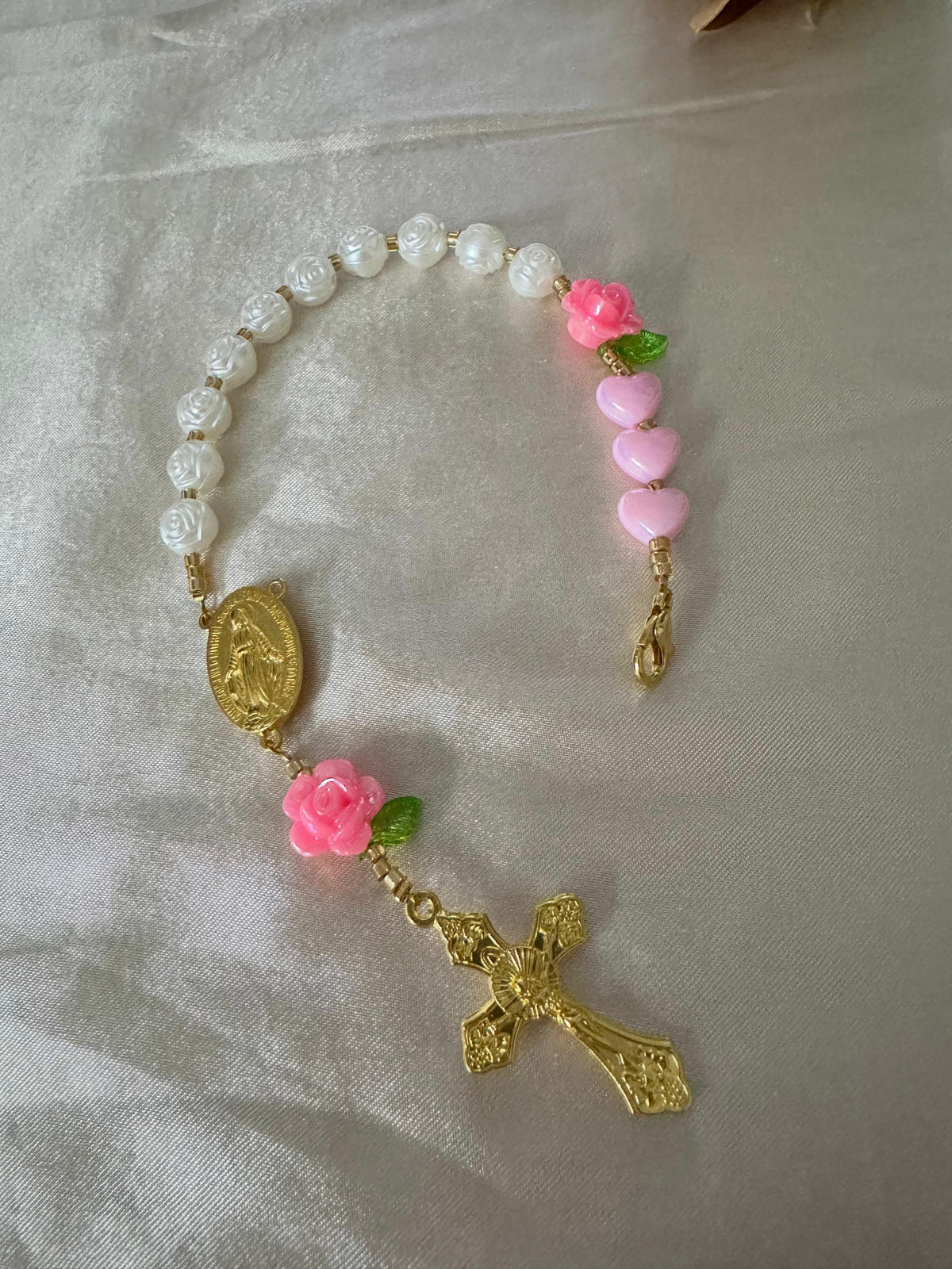 Pink Rose Mini Rosary with ivory rose beads, pink heart and flower beads, green leaves, and gold-tone clasp and crucifix.