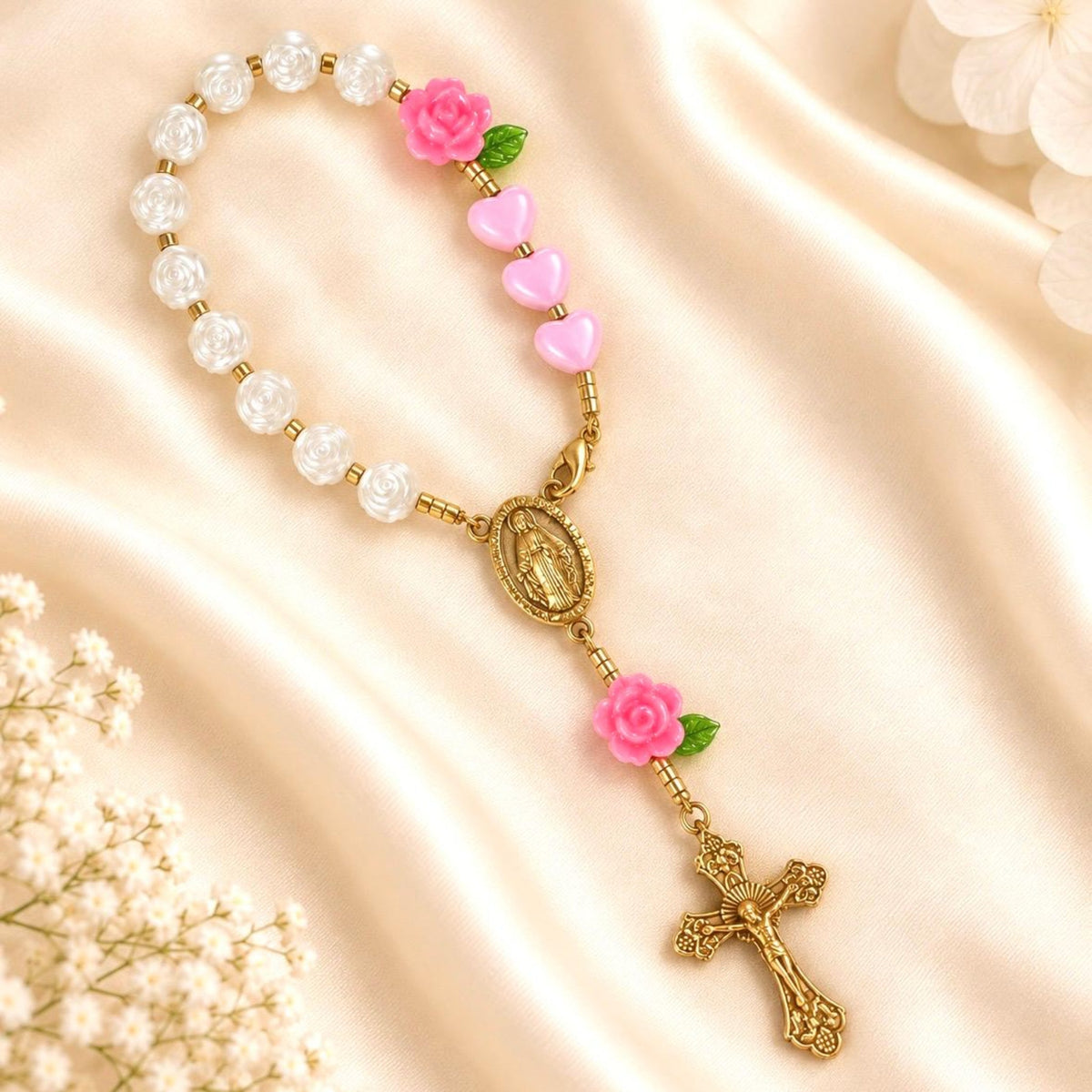 Pink Rose Mini Rosary with glossy white beads, pink heart beads, rose accents, green leaves, and gold-tone Mary centerpiece and crucifix
