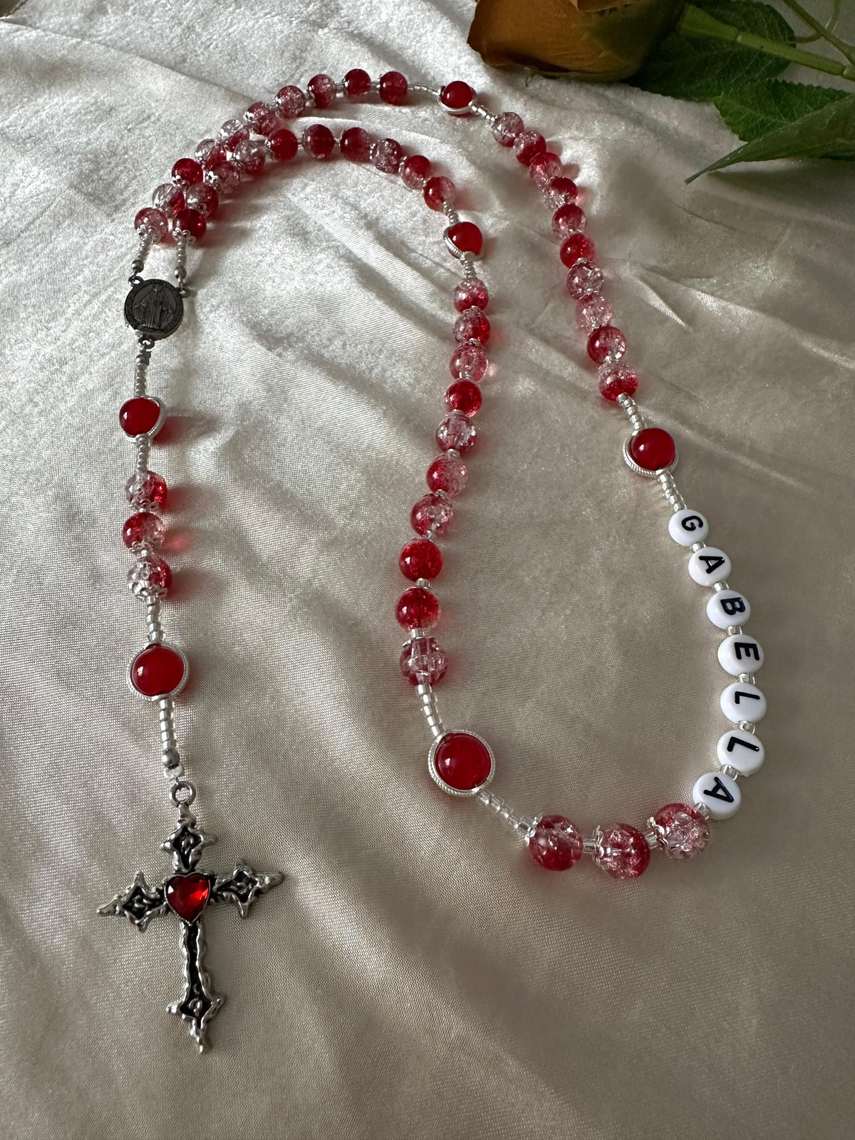 Red Personalized Handmade Rosary with red and clear glass beads, silver-tone flower caps, crucifix, and white name beads