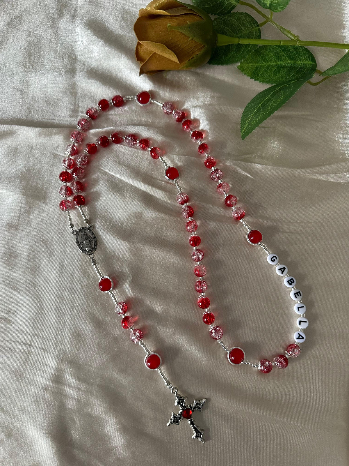 Red Personalized Handmade Rosary with red and clear glass beads, silver-tone crucifix, and white letter beads spelling a name