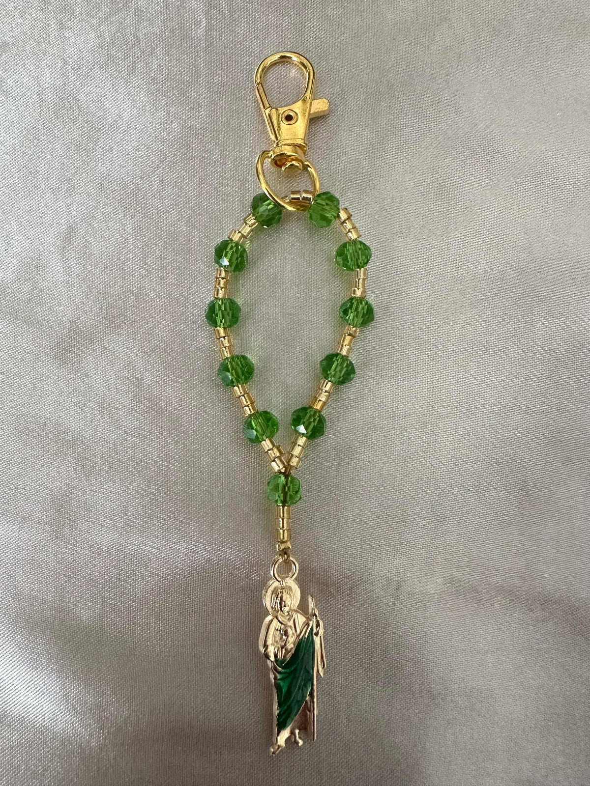 Sacred Hope Handmade Catholic Keychain with green faceted beads, gold-tone links and clasp, and a robed religious figure charm.